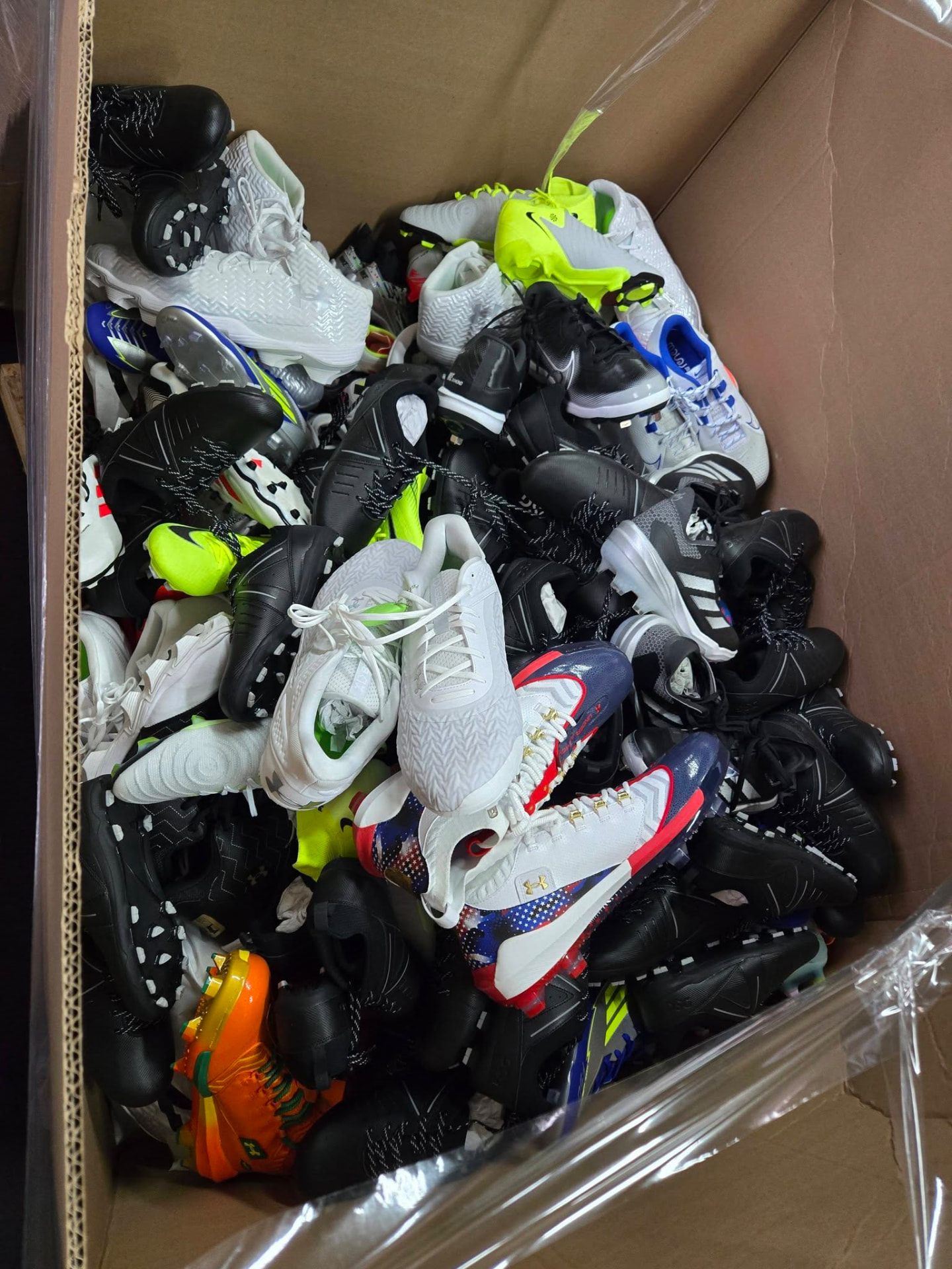 Box full of new Nike, Adidas and Under Armour cleats